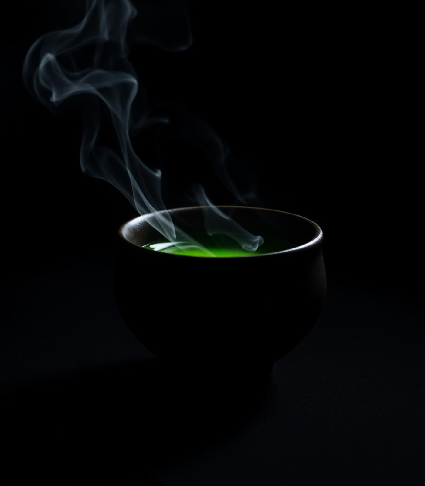 Steam rising from a dark chawan filled with whisked matcha